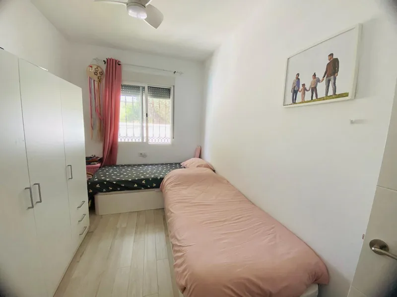 Tercer dormitorio con cama, luz natural y armario empotrado